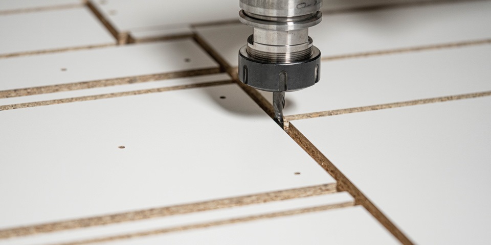 A drill cutting through a piece of wood
